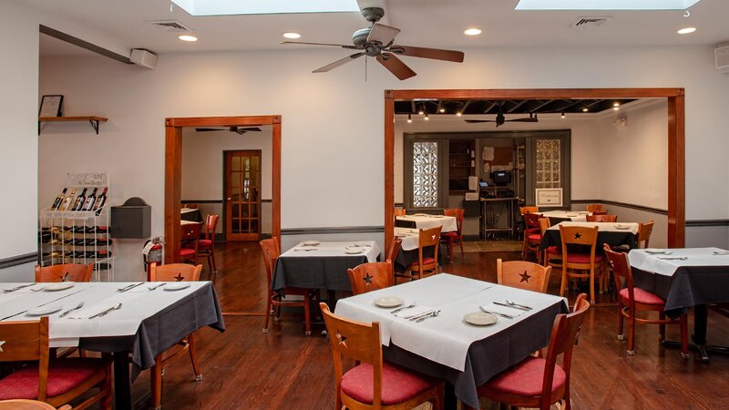 Dining room with set tables with white and black table cloths